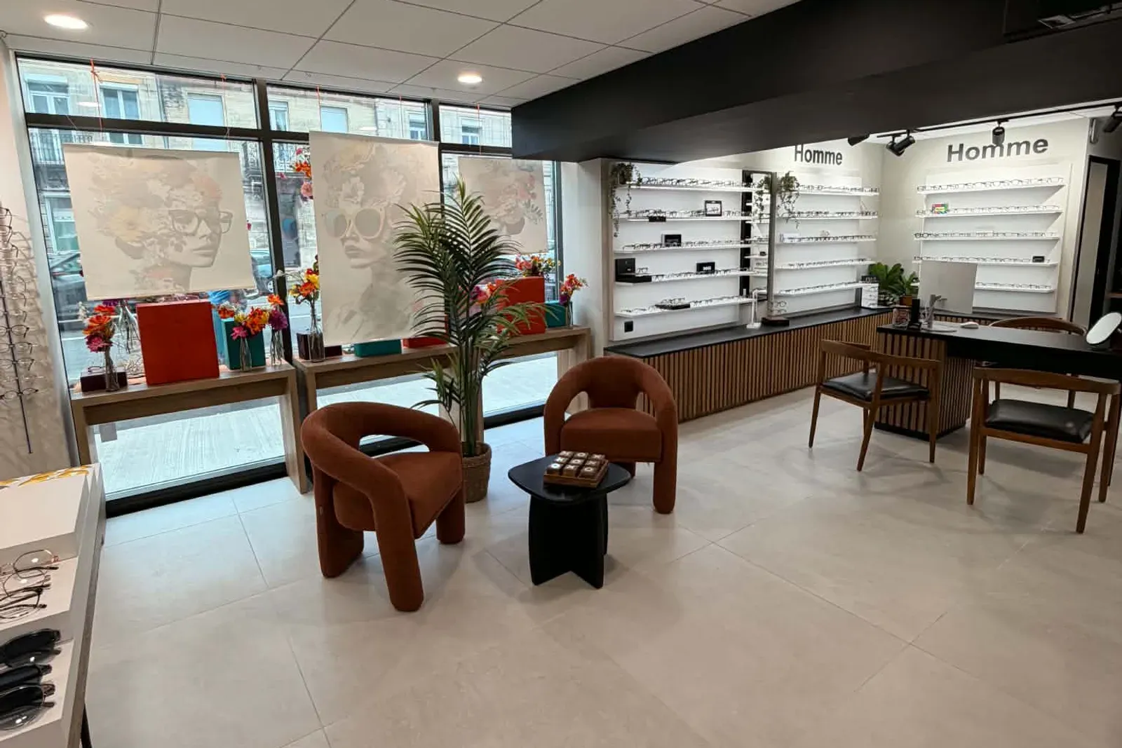Le coin salon du magasin : deux fauteuils ronds couleur terre cuite autour d'une table basse, devant la vitrine.