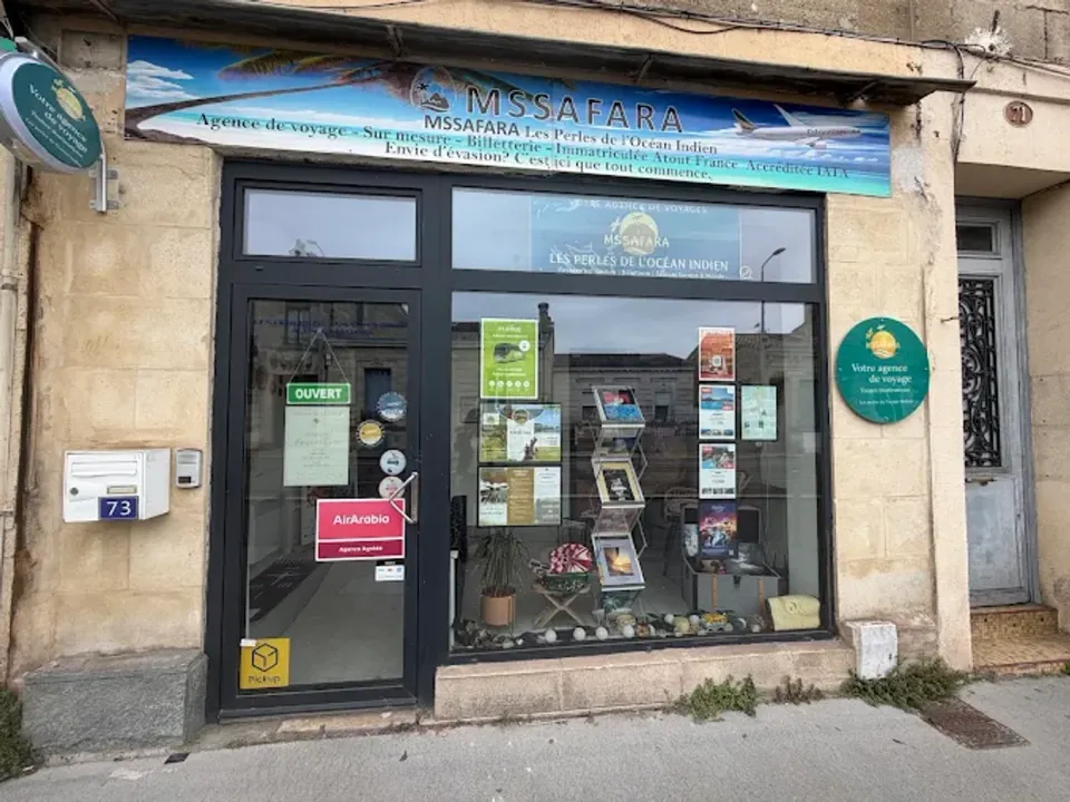 La devanture de l'agence MSSAFARA, cours Gambetta à Talence : une bannière bleue au-dessus de la vitrine, des brochures de voyage sur un présentoir et un panneau « Ouvert » accroché à la porte.